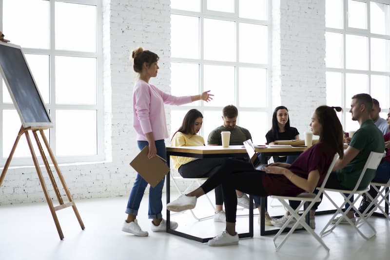 Eine Frau coacht in einem Bewerbungstraining junge Menschen