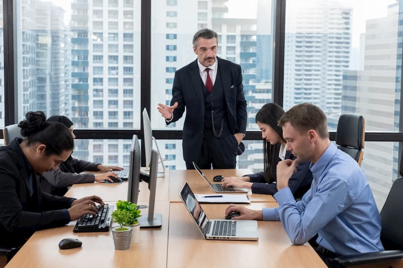 Ein Chef ist im Büro und erteilt seinen Mitarbeitern Anweisungen, dies darf er durch das Direktionsrecht