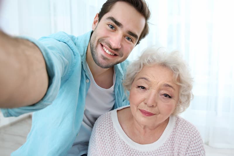 Ein junger Mann macht ein Selfie mit der Oma in der 4-Tage-Woche