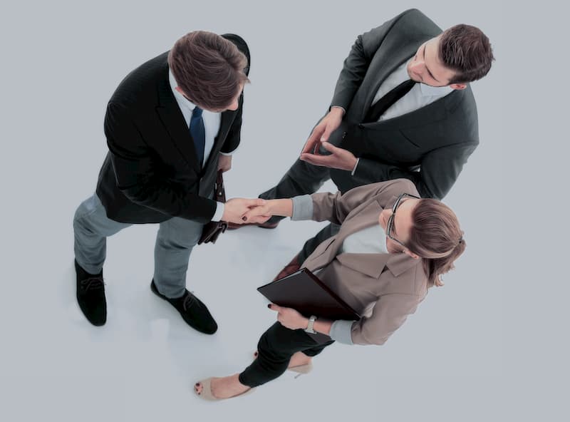Arbeitnehmervertreter schütteln die Hand mit einer Geschäftsführerin, nach dem Abschluss eines Tarifvertrags