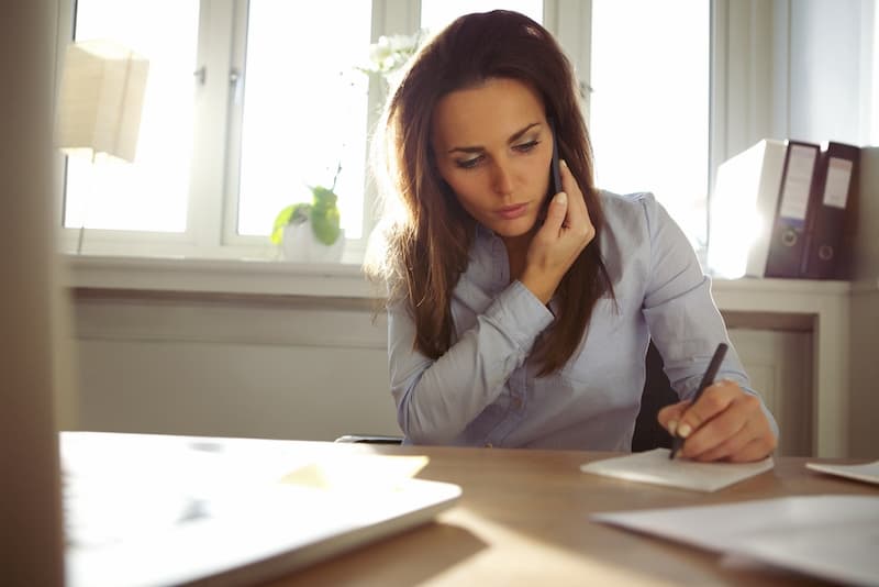 Eine Frau telefoniert auf der Arbeit privat und begeht Arbeitszeitbetrug