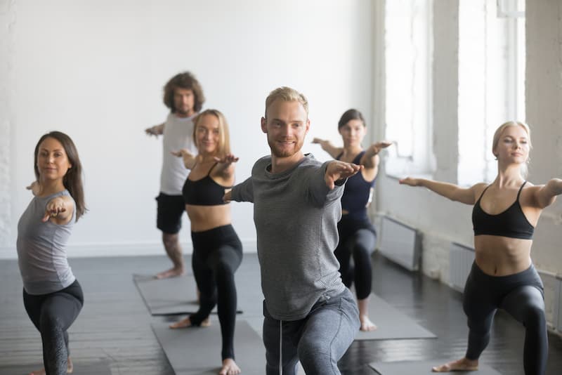 Kollegen machen zusammen einen Yoga-Kurs, dies gehört zu den Mitarbeiter-Benefits