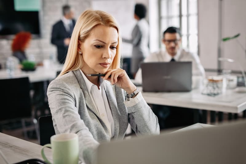 Eine Frau im Büro mit Sorgenfalten, sie hat eine Ermahnung erhalten