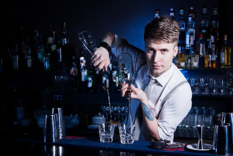 Ein Mann hat einen Zweitjob als Barkeeper und steht hinter der Theke