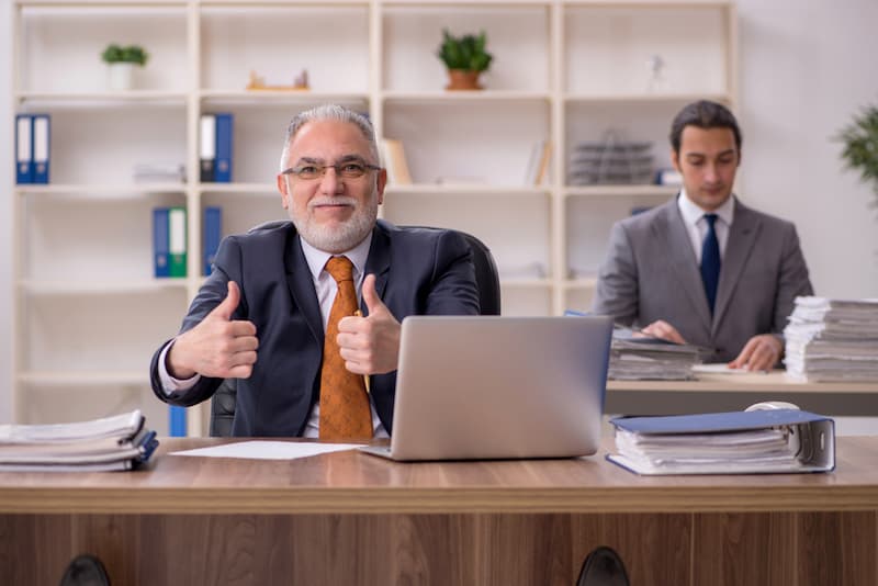 Ein älterer Herr im Büro, er freut sich auf den Ruhestand