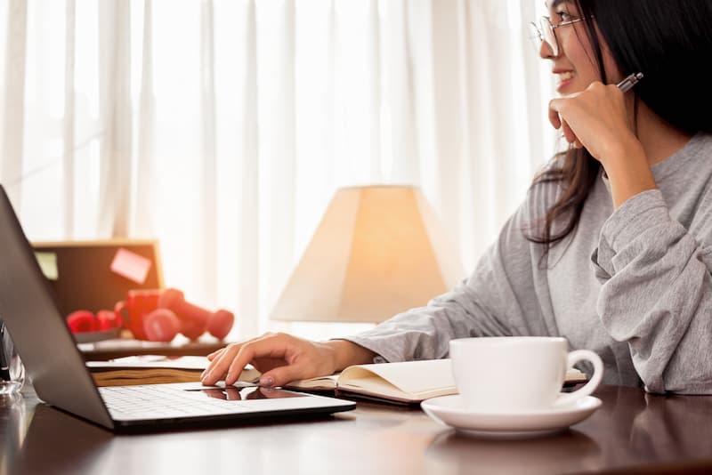 Eine Frau ist arbeitslos und sucht am Laptop einen Job