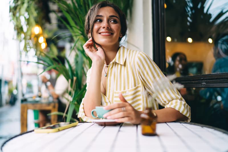 Eine Frau sitzt im Cafe und hat Rufbereitschaft