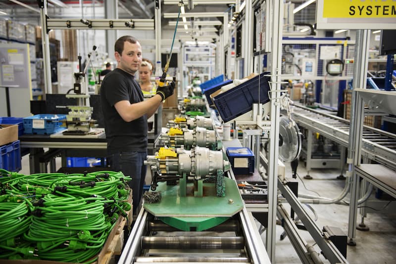 Ein Mann arbeitet an einem Fließband in Schichtarbeit