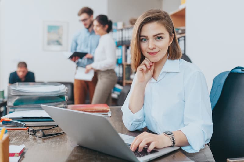 Eine Frau nach der Umschulung als Bürokauffrau am Schreibtisch mit Laptop