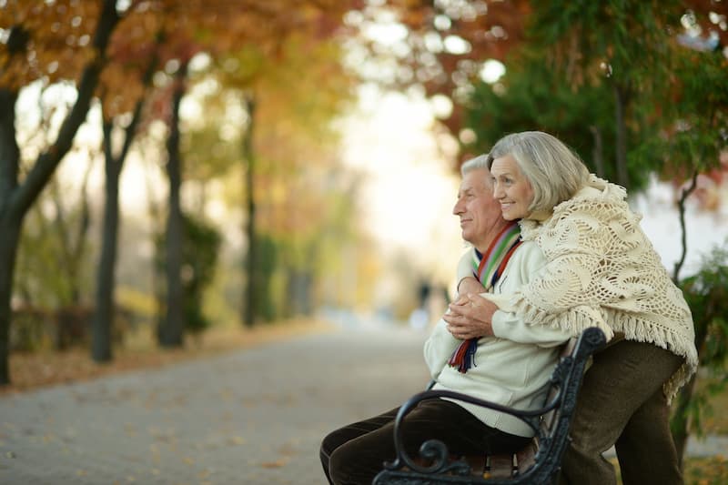 Ein älteres Ehepaar auf einer Parkbank, sie leben nicht in Altersarmut