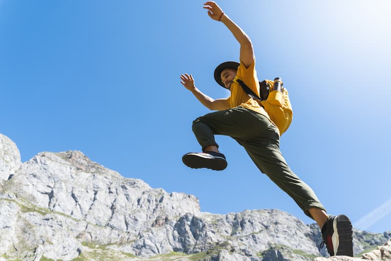 Ein Mann springt durch das Gebirge, ein Symbolbild für einen Jobhopper