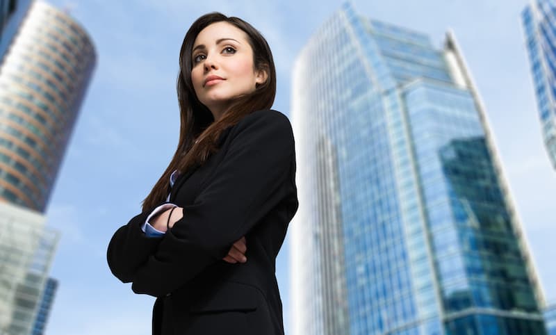 Eine Frau steht vor Wolkenkratzern, sie ist ein Beispiel für Female Leadership