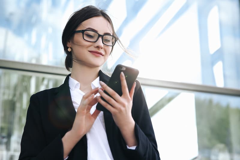 Eine Frau hält ein Firmenhandy in der Hand