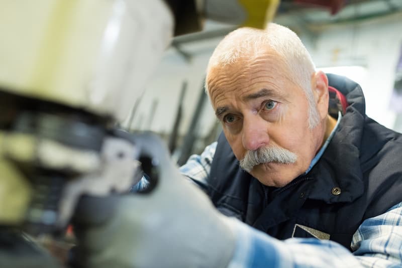 Ein älterer Mitarbeiter bei der Arbeit, er profitiert von der Unkündbarkeit