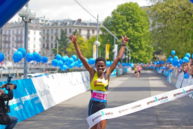 Eine Frau läuft bei einem Marathon in ein Ziel ein, ein Beispiel für Zielstrebigkeit