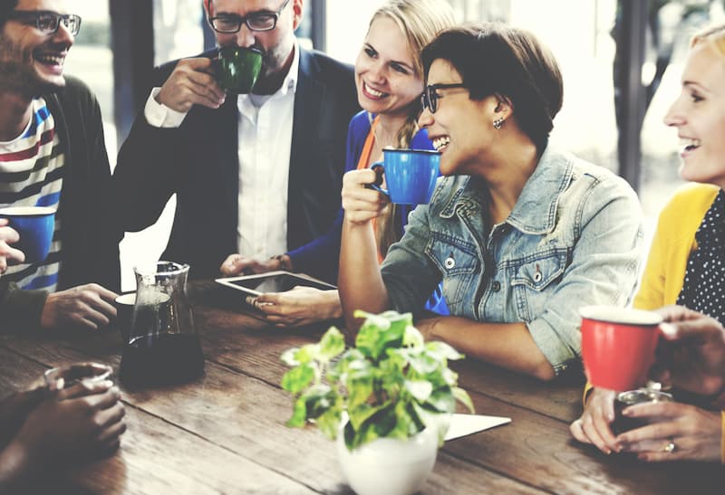 Mehrere Menschen in einem Cafe, sie betreiben Networking