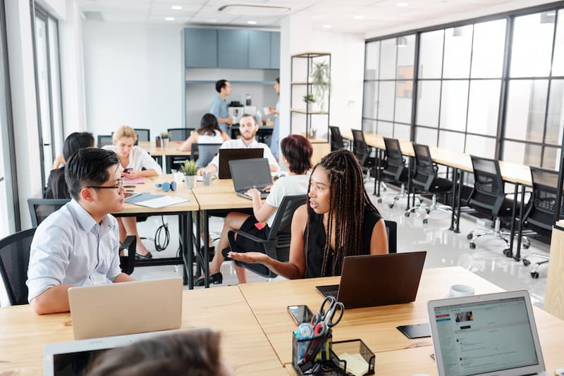 Mehrere Mitarbeiter an einem Modern Workplace im Büro