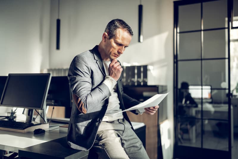 Ein Mann liest seinen Arbeitsvertrag nach der Entfristung