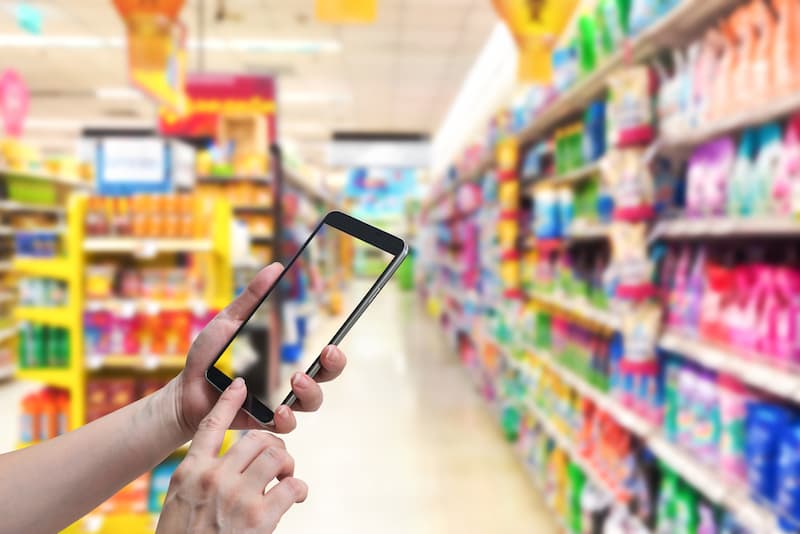 Ein Mensch fotografiert im Supermarkt, eine Form von Crowdworking