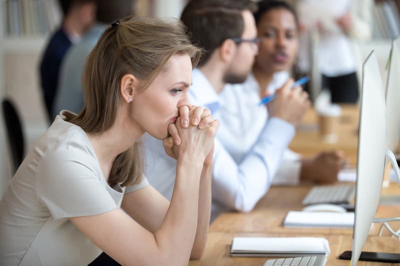 Eine Frau sitzt nachdenklich am Arbeitsplatz, sie sitzt in der Teilzeitfalle