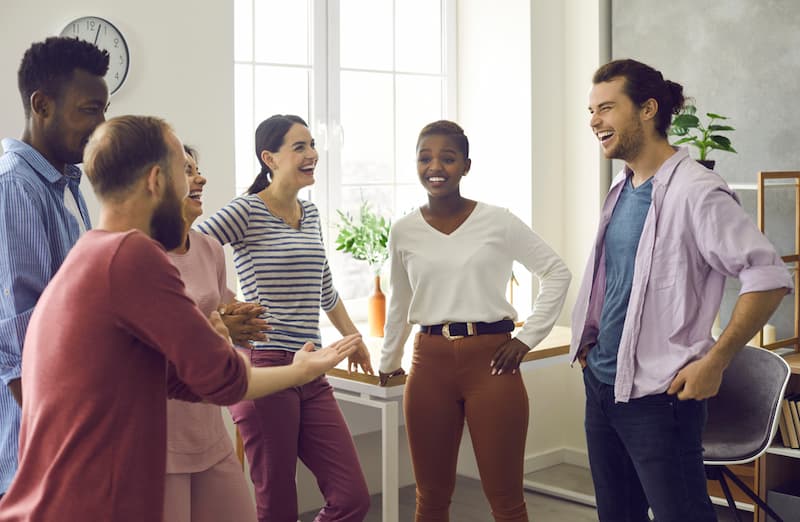 Mehrere Mitarbeiter lachen zusammen, was gibt es für lustige Abschiedsworte?