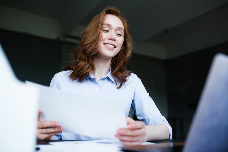 Eine Frau durchblättert ihre Unterlagen, wer zahlt die Krankenversicherung im Minijob?