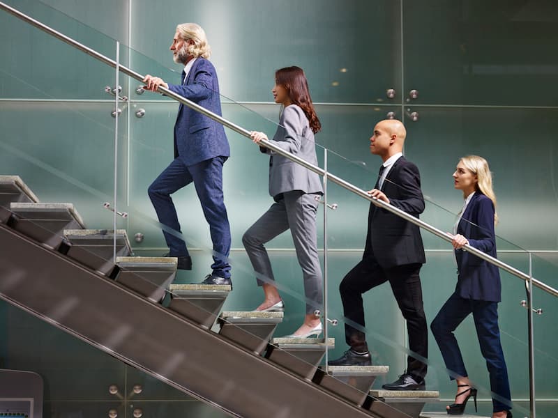 Mehrere Menschen gehen eine Treppe hoch, wie macht man Karriere?