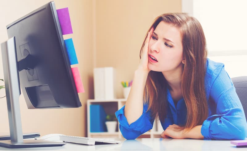 Eine Frau sitzt gelangweilt im Büro, welche Probleme bereitet Perspektivlosigkeit?