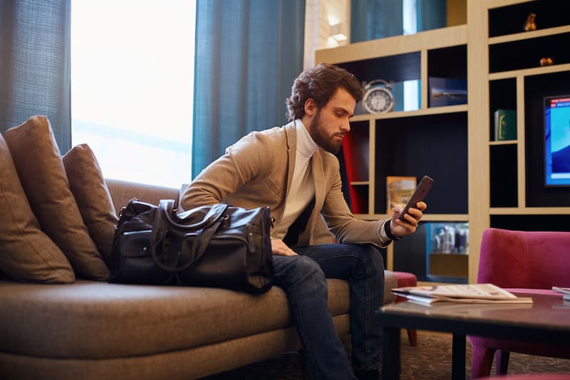 Ein Mann schaut Zuhause auf sein Handy, was ist Arbeit auf Abruf?