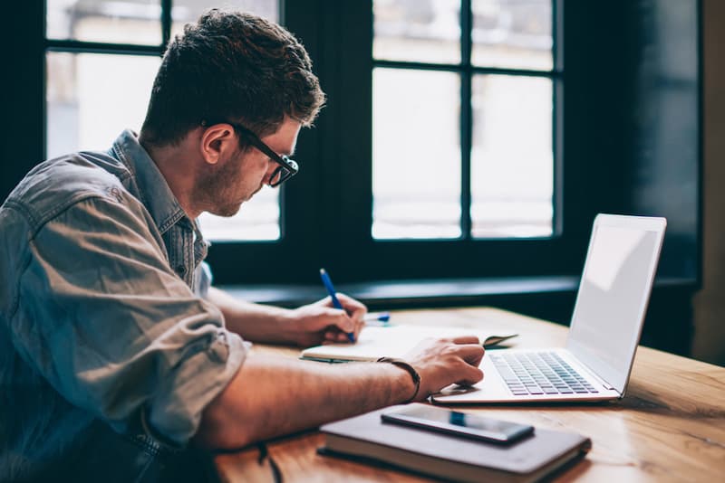 Ein Mann arbeitet am Laptop, was sind freie Berufe?