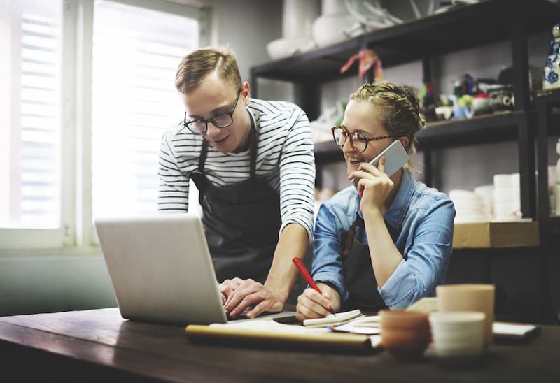 Zwei Menschen vor dem Laptop, sie möchten ein Unternehmen gründen