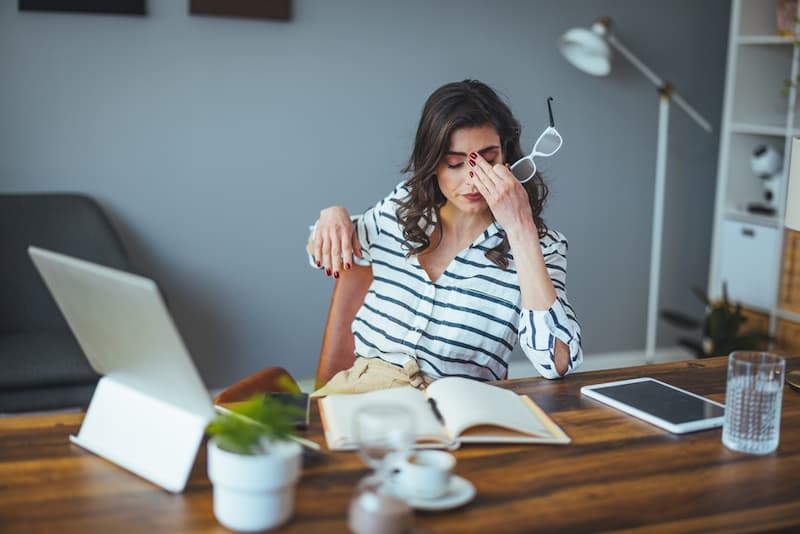 Eine Frau sitzt besorgt am Schreibtisch, kann man den Arbeitgeber abmahnen?