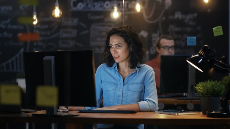 Zwei Mitarbeiter sitzen abends im Büro, was ist ein Workaholic?