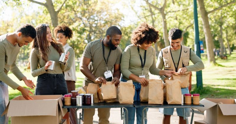 Gruppe junger Menschen leistet soziale Arbeit im Park