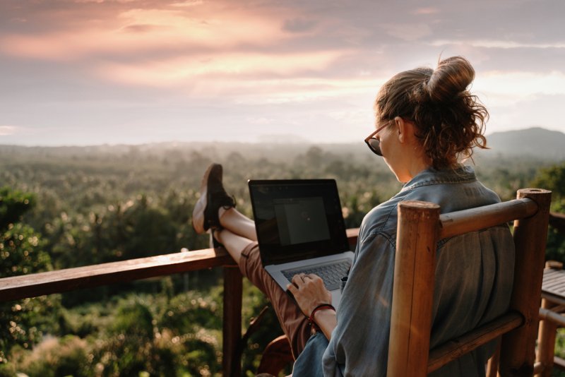 Eine Frau mit Laptop vor Aussichtspunkt