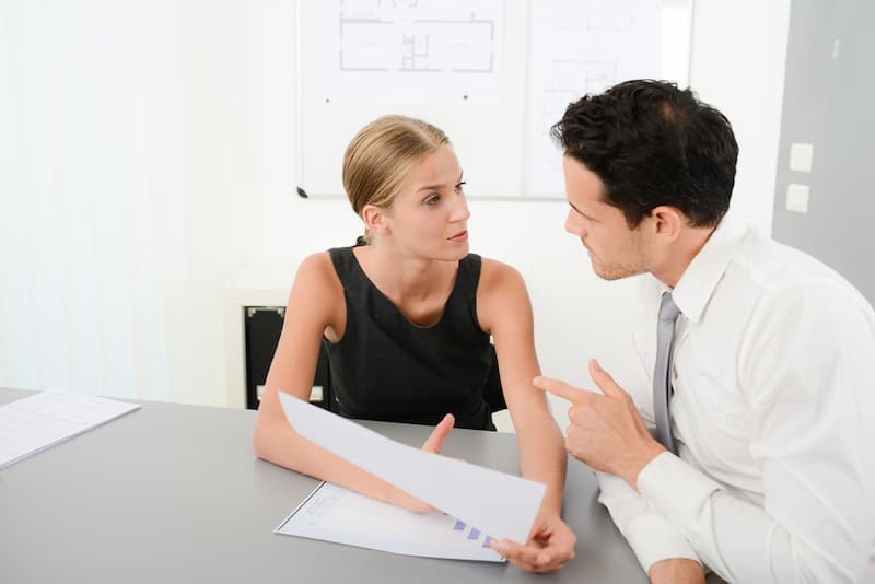 Eine Chefin führt ein Kritigespräch mit einem Angestellten