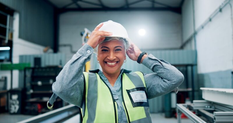 Mental starke Mitarbeiterin mit Helm und Warnweste.